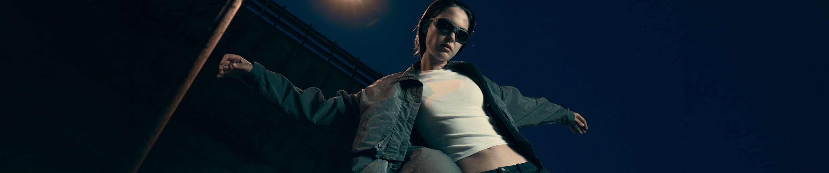 Two people posing with a car, one inside and one leaning on the door.