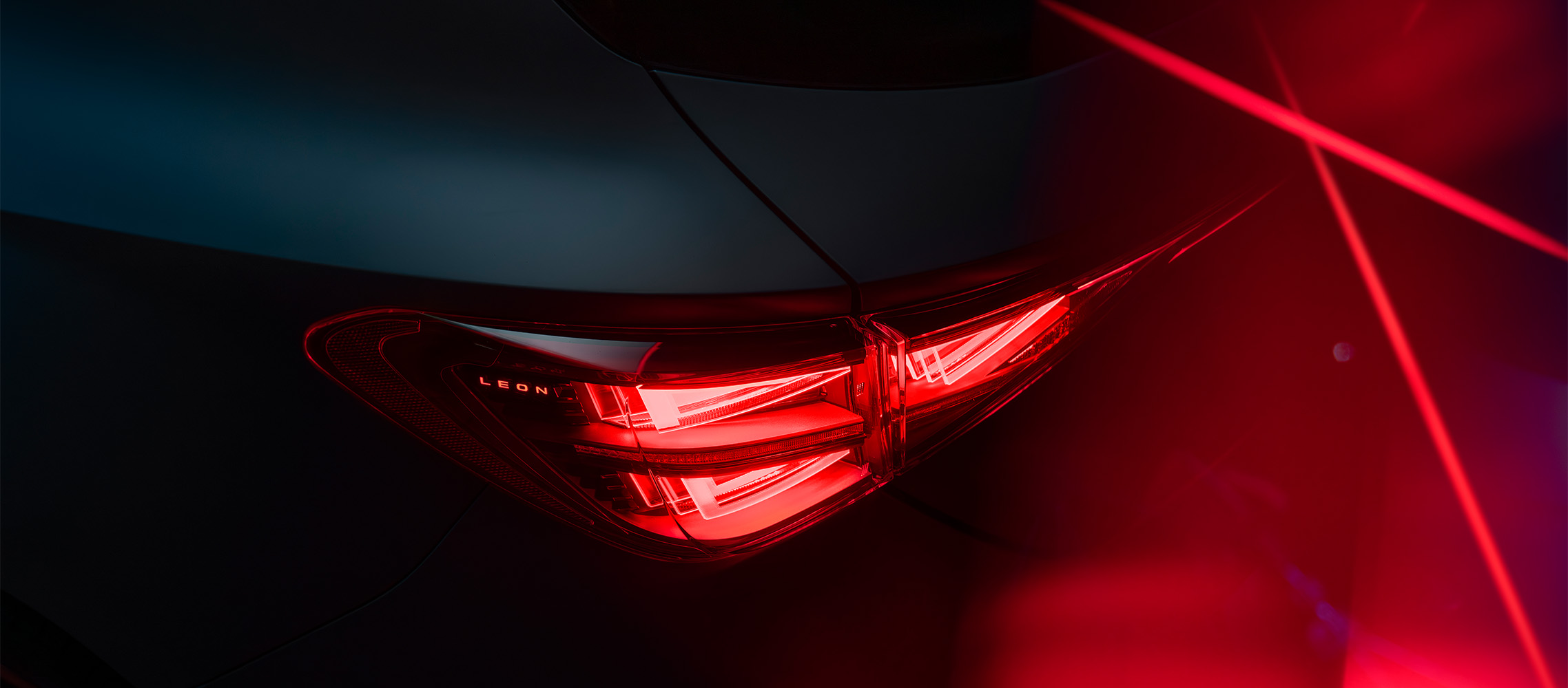 side view of a new 2024 cupra leon's red rear light, highlighting the sleek lines and lighting design against a dark background.​