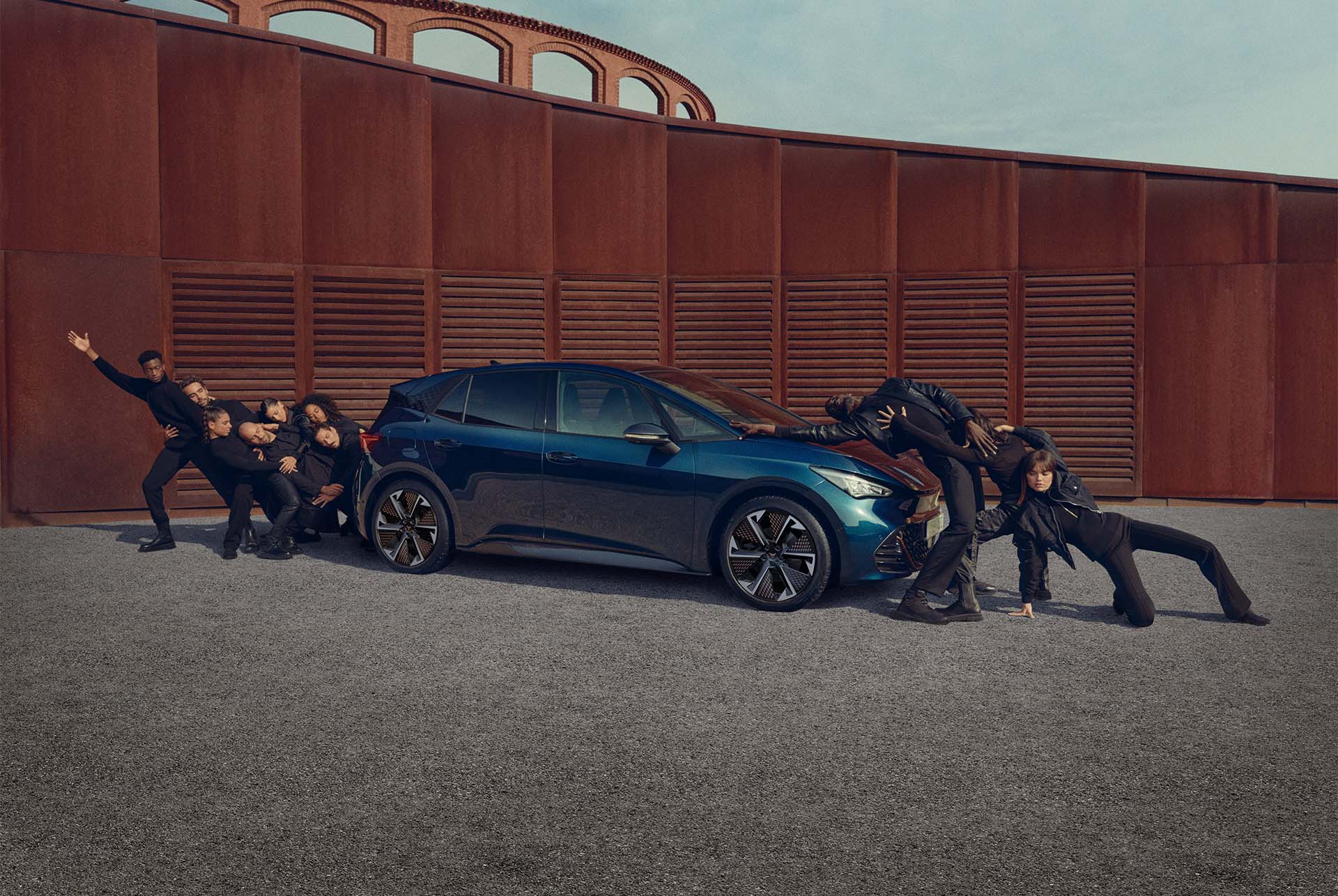 Des personnes posant sur la CUPRA Born Aurora Blue.