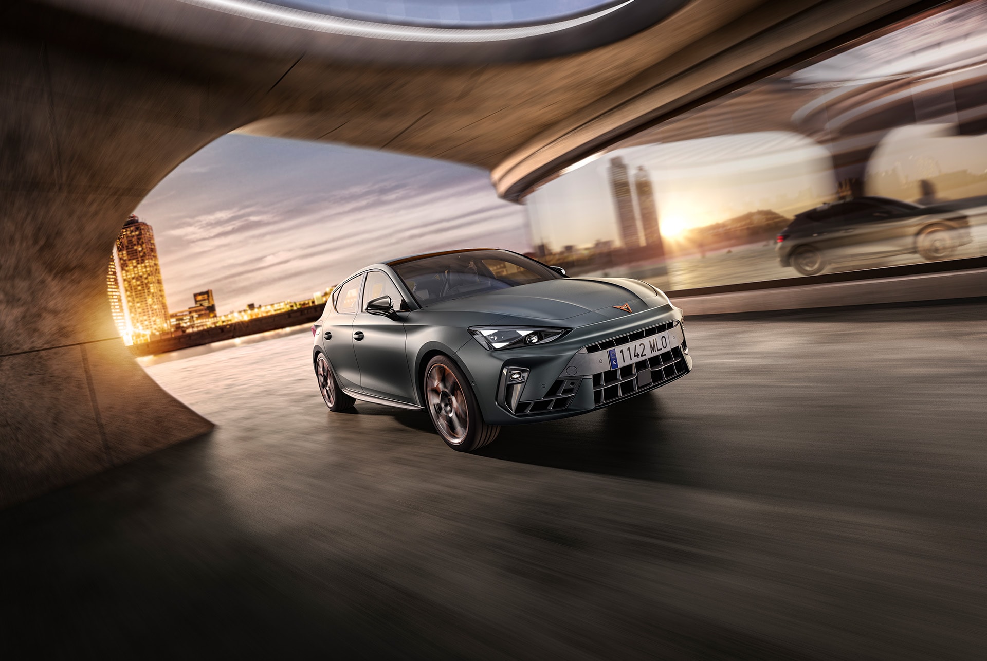 three quarter front view of a new grey cupra leon 2024 in motion, Barcelona cityscape in the background and reflection.