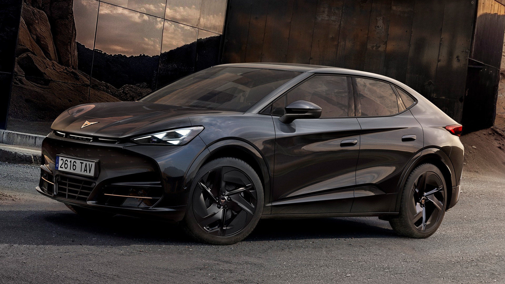 Vue de profil, en trois quarts de face, de la CUPRA Tavascan Black Edition, garée dans un décor rocheux et mettant en valeur ses détails extérieurs, tels que les jantes en alliage Katla de 21 pouces, de couleur noire.