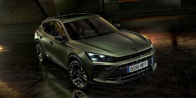 CUPRA Formentor in matte green finish parked indoors with dramatic lighting and industrial design elements.